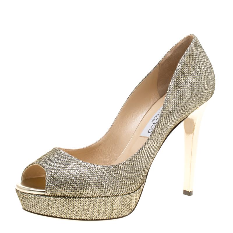 Look no less than a diva in these Dahilia pumps from Jimmy Choo. Crafted from metallic gold lamè fabric, they are lined with leather on the inside. This pair carries 12 cm heels with supporting platforms. Complete with peep toes, you can complement