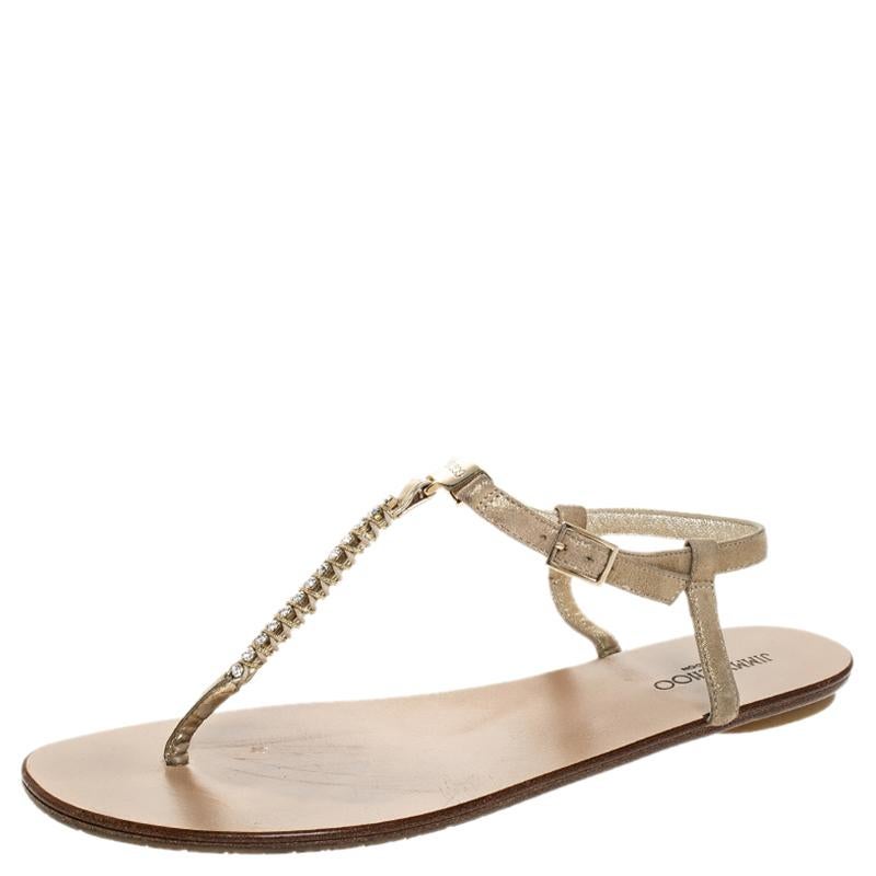 These thong sandals by Jimmy Choo are perfect to be paired with any outfit of your choice. These suede sandals are edgy and chic. They are crafted from metallic gold suede and feature crystal embellishments on the t-straps, buckled ankle straps and