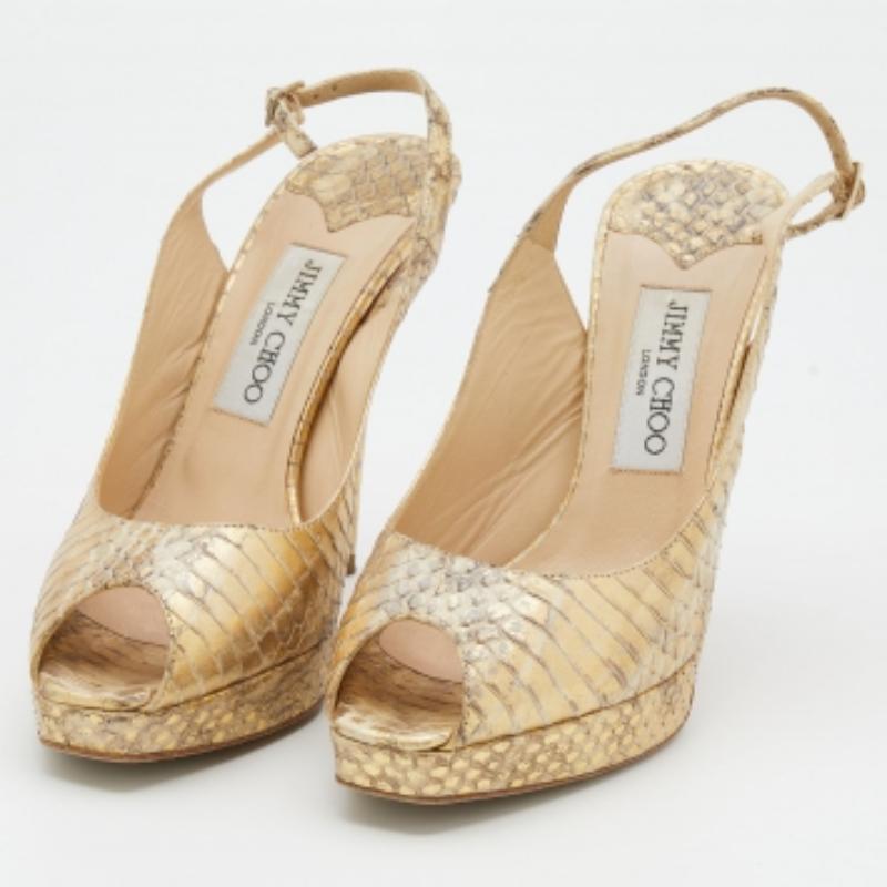 Estos elegantes zapatos de salón de Jimmy Choo son el par de fiesta más versátil que puedas tener. Se han confeccionado en Italia y están hechos de piel de pitón. Estos zapatos de salón dorados metalizados tienen peep toes, tacón de 12 cm, tira con