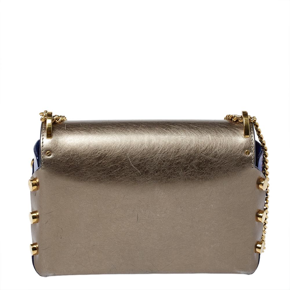 One of the signature detail of the Lockett by Jimmy Choo is the push-lock that has a pointed bottom. This shoulder bag boasts the same accent on its flap which secures a suede interior for your needs. The bag has a metallic grey & blue exterior,