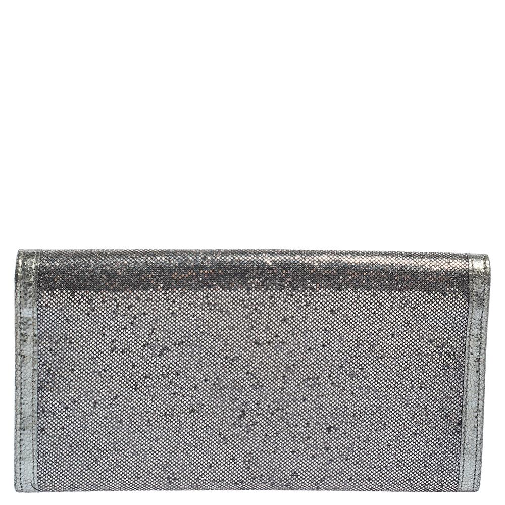 The Jimmy Choo Reese clutch is both practical and glamorous. Crafted from metallic leather and glitter, this Italian-made wallet is presented in a streamlined silhouette. The front flap with a gleaming logo plaque opens to a fabric and leather