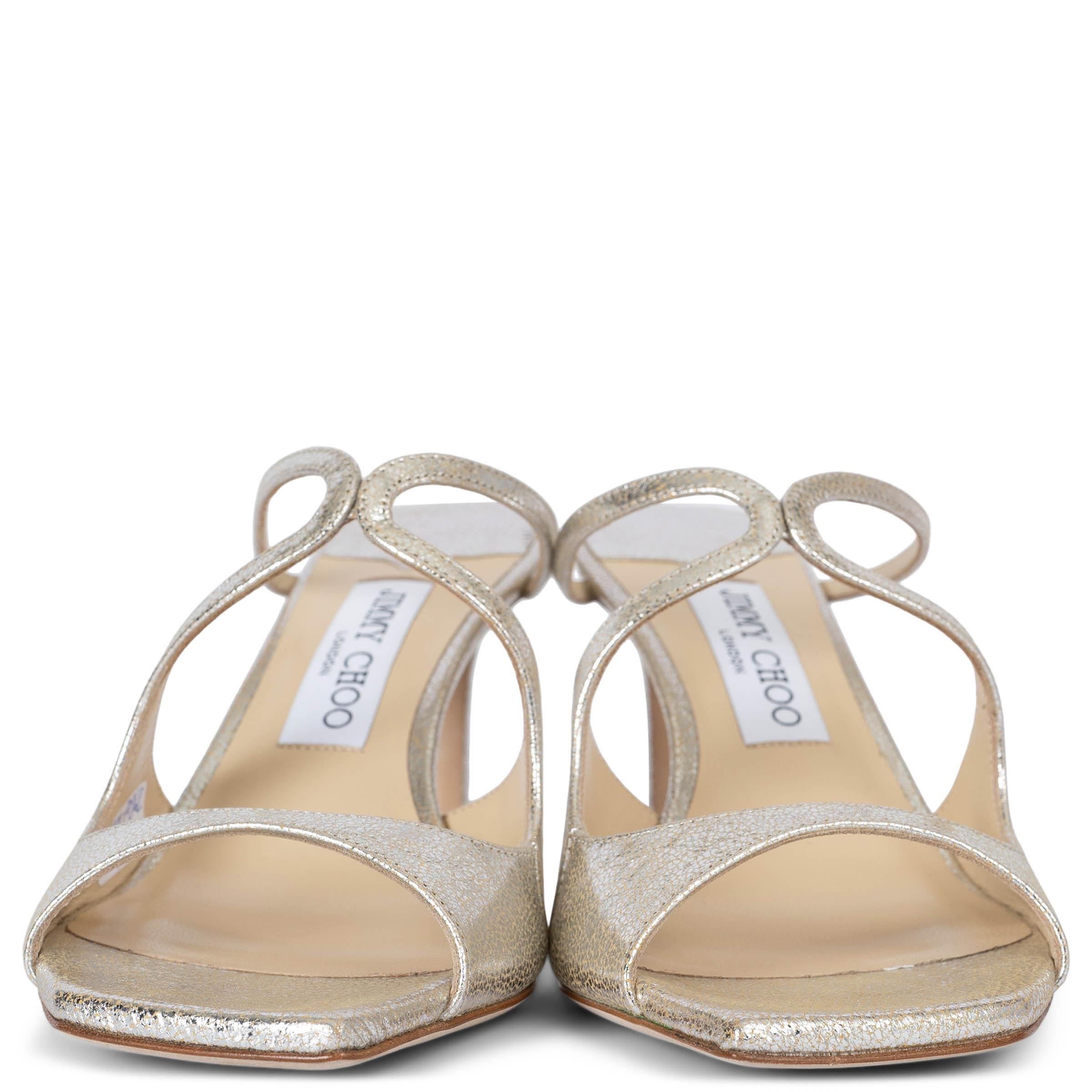 These 100% authentic Jimmy Choo Anise Mule 75 is a glamorous and stylish choice, perfect for adding a touch of elegance to any outfit. Crafted from luxurious metallic champagne colored leather, these mules feature eye-catching graphic cut-outs and