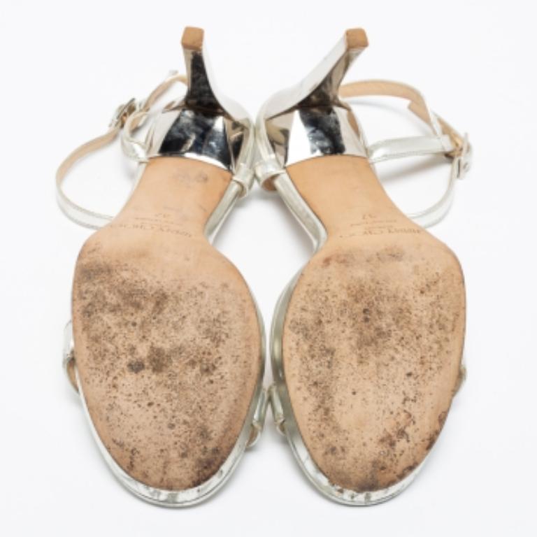 These sandals by Jimmy Choo carry a design that will impress any fashion lover. Created from silver leather, they exhibit a single strap on the vamps, an ankle buckle closure, and silver-tone hardware. The 10cm heels and platforms of this pair will