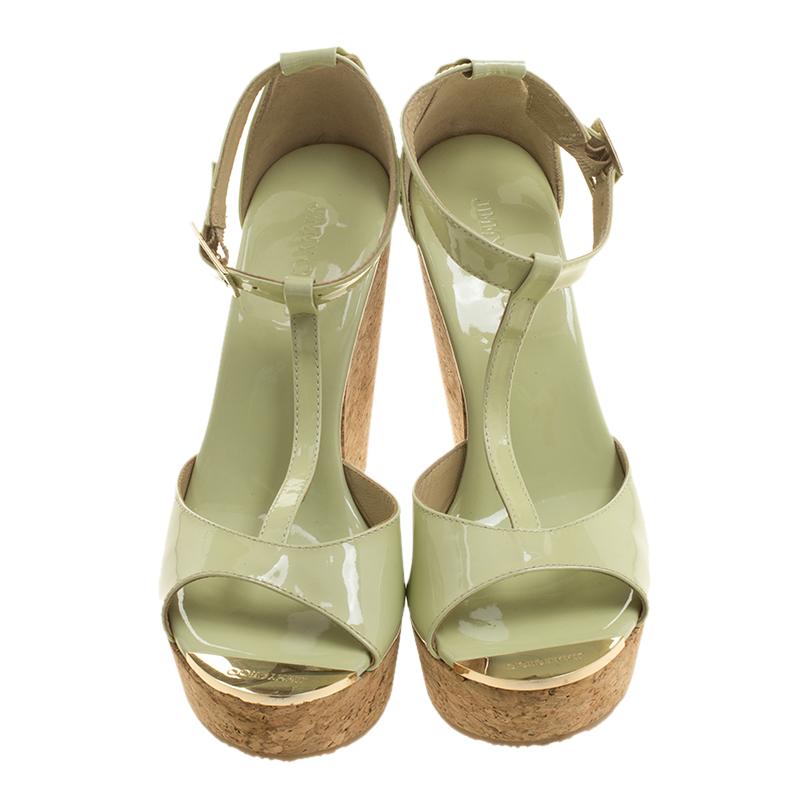 Welcome the summer in style in these stunning Jimmy Choo Mint Green Patent Leather Pela Cork Wedge Sandals. These are crafted from a flashy mint green patent leather with ankle straps and almond shaped peep toes that stand on high platform wedges.