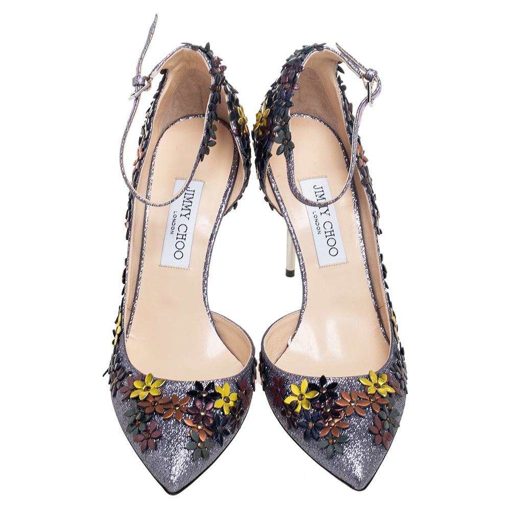 These Lorelai pumps from the House of Jimmy Choo will help you take every step with confidence and style! They are crafted using multicolored glitter and leather, with floral embellishments throughout. They showcase an ankle strap, silver-tone