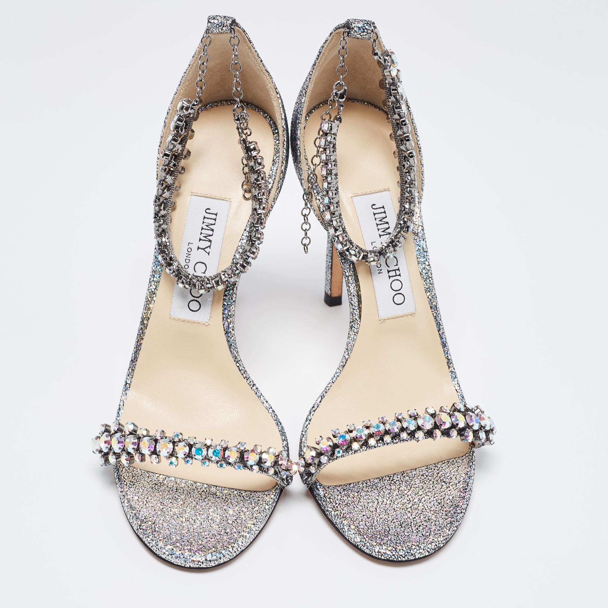 The Jimmy Choo sandals are a luxurious and elegant footwear choice. Featuring open toes and stiletto heel, these shoes are crafted with crystal-embellished straps. They effortlessly blend timeless sophistication with contemporary style, making them