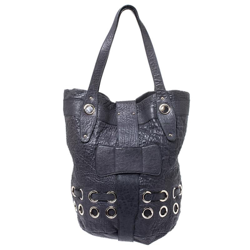 This gorgeous Jimmy Choo Ramona tote is crafted from leather and designed with a belt detailing and a front flip-lock. The piece is equipped with a well-sized Alcantara interior and is complete with dual handles. A stylish bag like this one is a