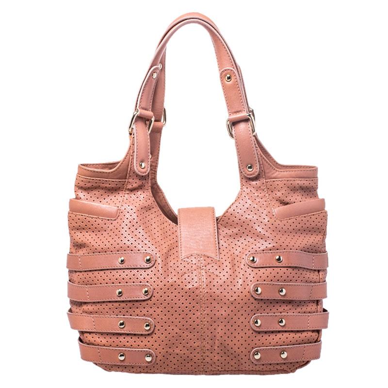 Make everyone nod in approval when you step out swinging this nude pink Jimmy Choo Bardia bag. It has been crafted from perforated leather and styled with buckle detailing on the sides. The interior is suede-lined and the bag is completed with dual