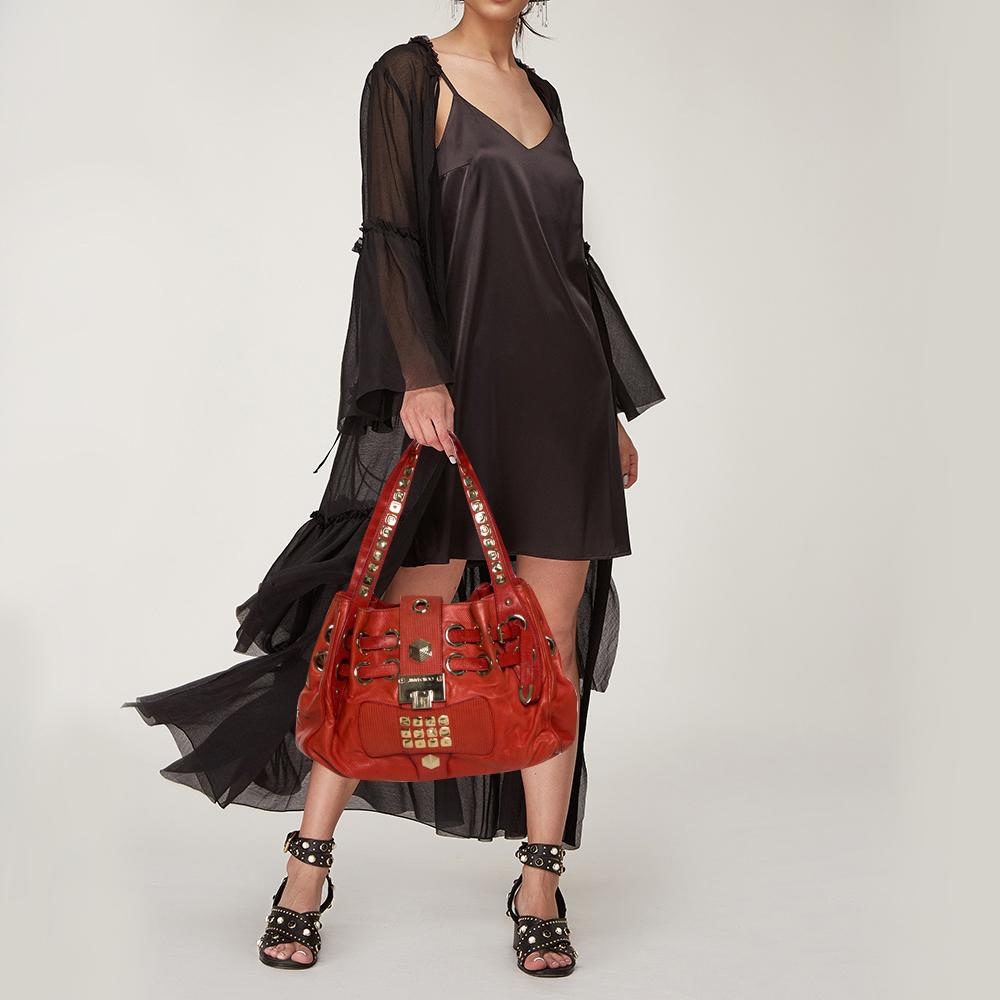 Own this gorgeous Jimmy Choo Riki bag today and light up your closet! Crafted from patent leather, this stunning number has a flap top with a signature lock and a spacious Alcantara interior. It also features two top handles, gold-tone hardware, and