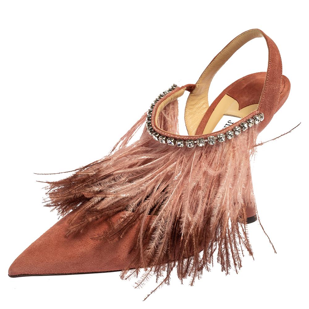 Jimmy Choo never fails to amaze and charm us! These stunning Ambre pumps have been designed creatively with feathers that beautifully adorn the pink suede construction. They are styled with pointed toes and crystal-embellished mid vamp straps and