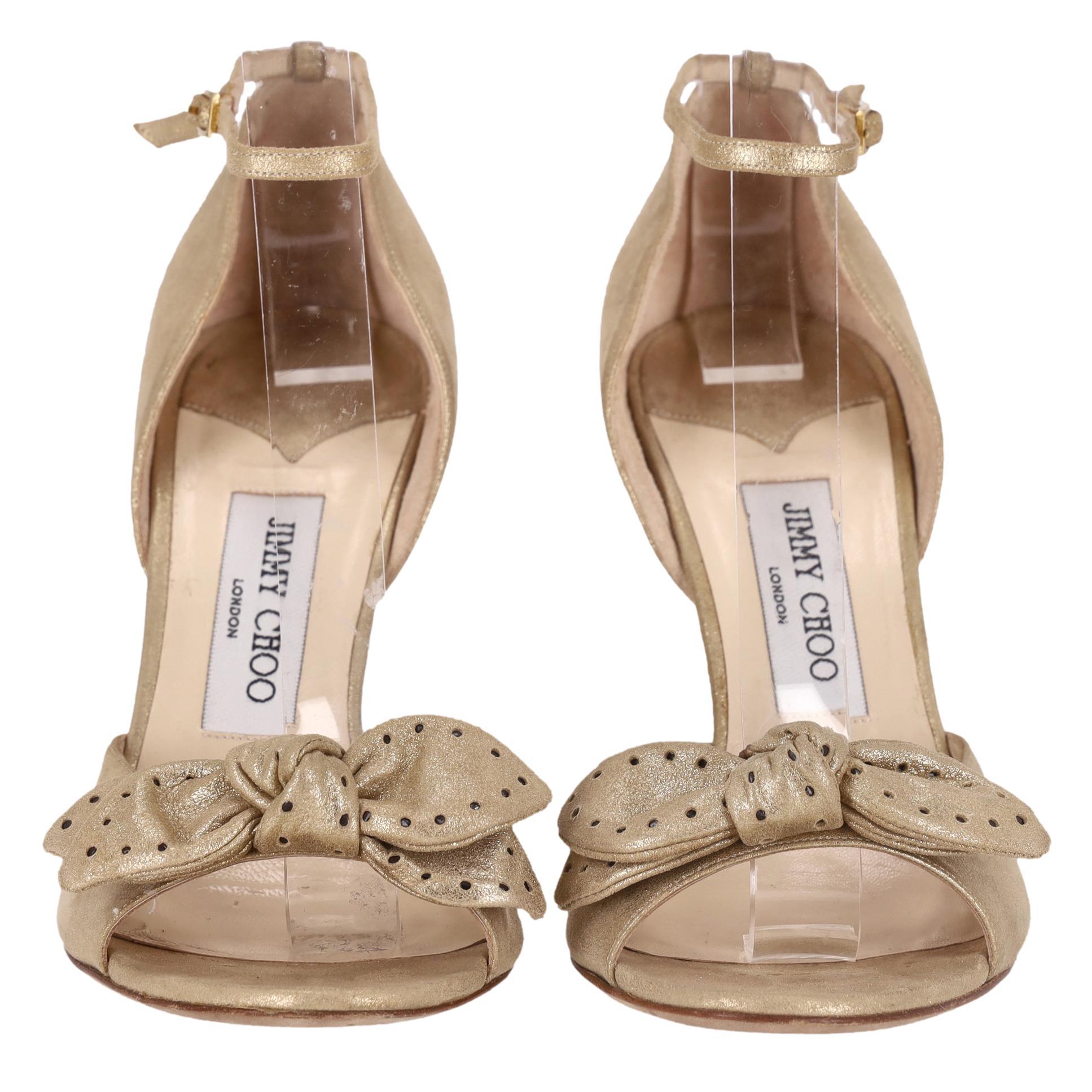 Jimmy Choo - Sandales métalliques à nœuds embellies par des pois

Sandales en cuir métallisé couleur champagne, dotées d'un nœud découpé à motifs de pois.

Il est doté d'un bout ouvert, d'une bride de cheville et d'un talon aiguille.

Rrp Approx.
