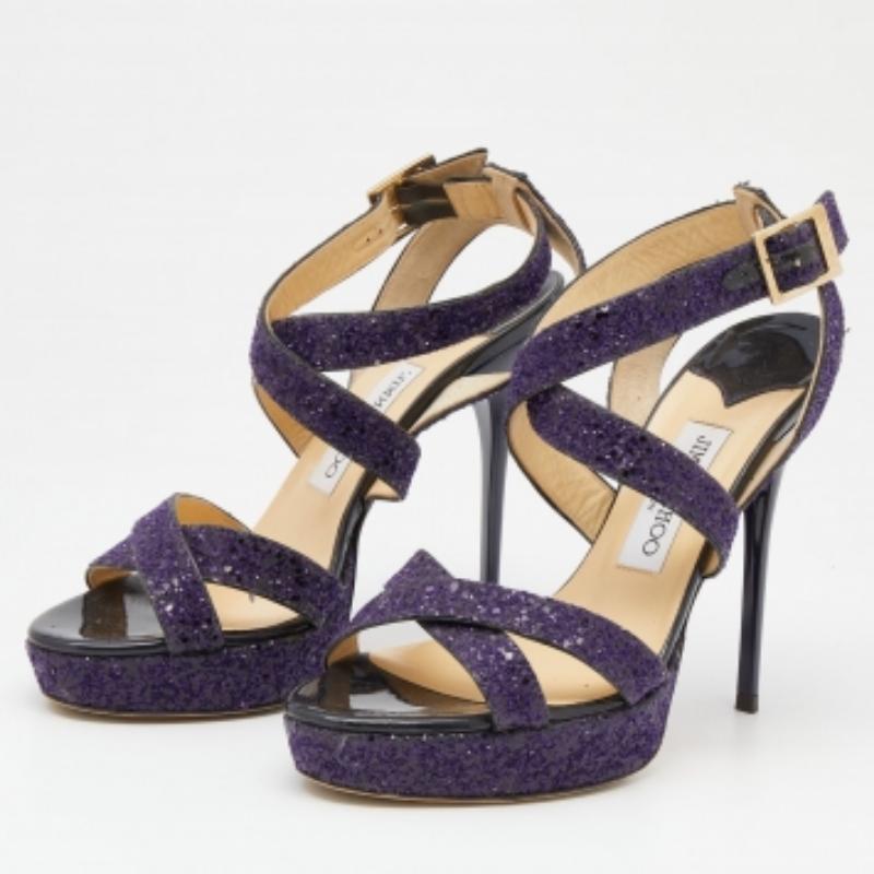 Feal ogni volta che esci con questi sandali con plateau di Jimmy Choo! Realizzate in glitter con un design a strappo incrociato, presentano un fascino incantevole. Il paio viola ha la punta aperta, il tacco a spillo e le fibbie alle caviglie.