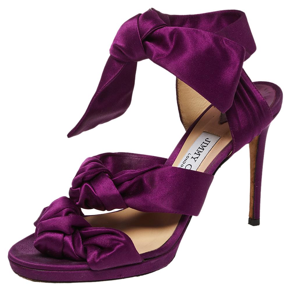 Verleihen Sie Ihrem Outfit mit diesen lilafarbenen Sandalen von Jimmy Choo ein besonderes Finish. Die geknoteten Satinbänder verleihen den Schuhen einen besonderen Reiz. Niedrige Plateaus, Knöchelriemen und 10 cm hohe Absätze machen die Sandalen