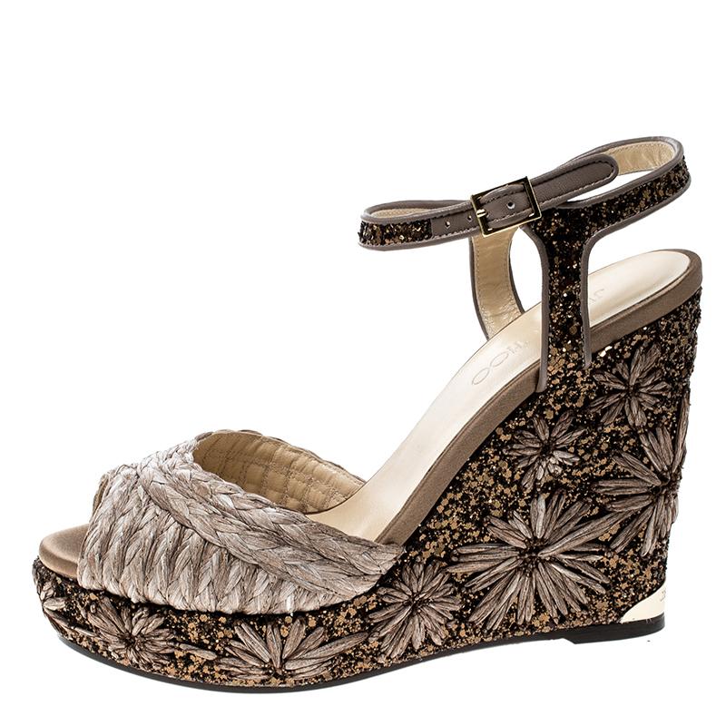 Feel the admiring glances coming your way whenever you waltz out in this pair of gorgeous sandals from Jimmy Choo. They've been crafted from raffia, leather trims and decorated with coarse glitter on the ankle straps and 12.5 cm wedge