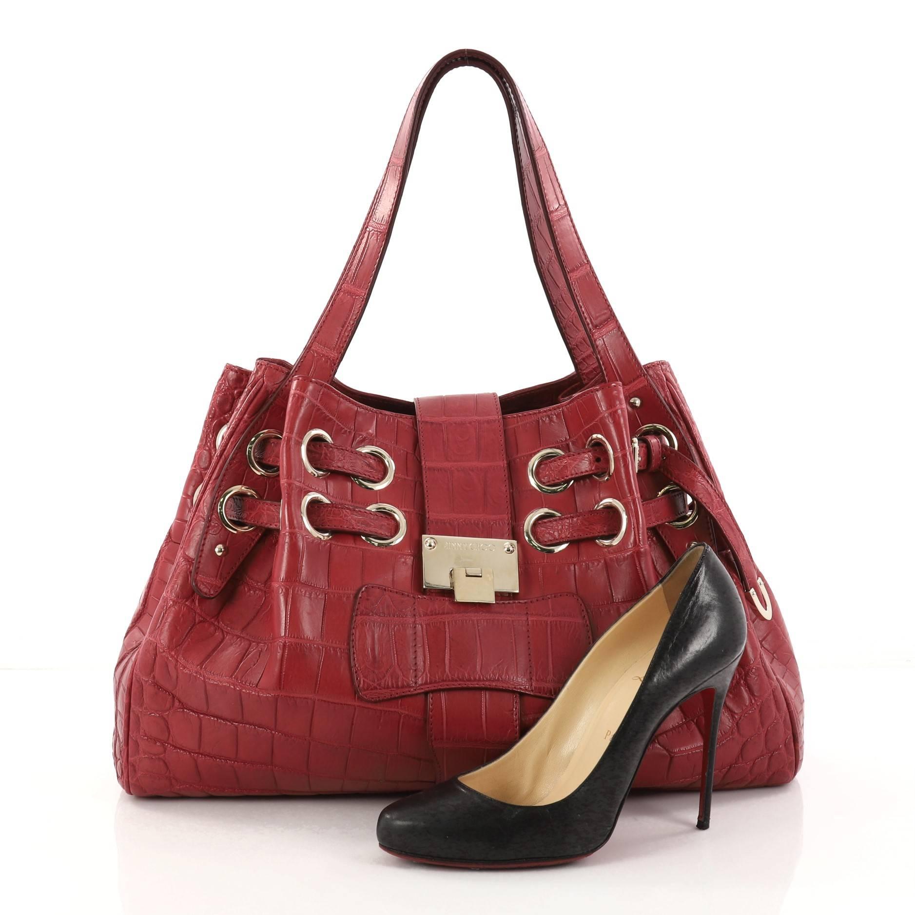 This authentic Jimmy Choo Ramona Hobo Crocodile is sophisticated and easy-to-carry made for everyday excursions. Constructed from red genuine crocodile skin, this hobo features multiple wrapped slim straps laced through metal eyelets, dual flat top