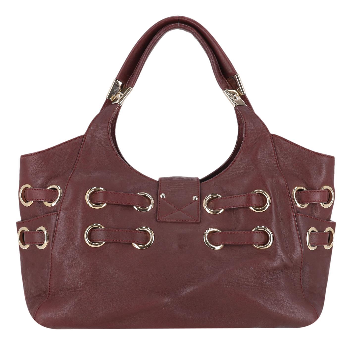 Jimmy Choo Ramona Leather Tote Bag

Burgundy wine tote bag crafted from soft calfskin leather.

Adorned with gold buckles, and front lock with 'Jimmy Choo' engraving.

Dual top handles and spacious interior with zipped and open compartments.

Rrp