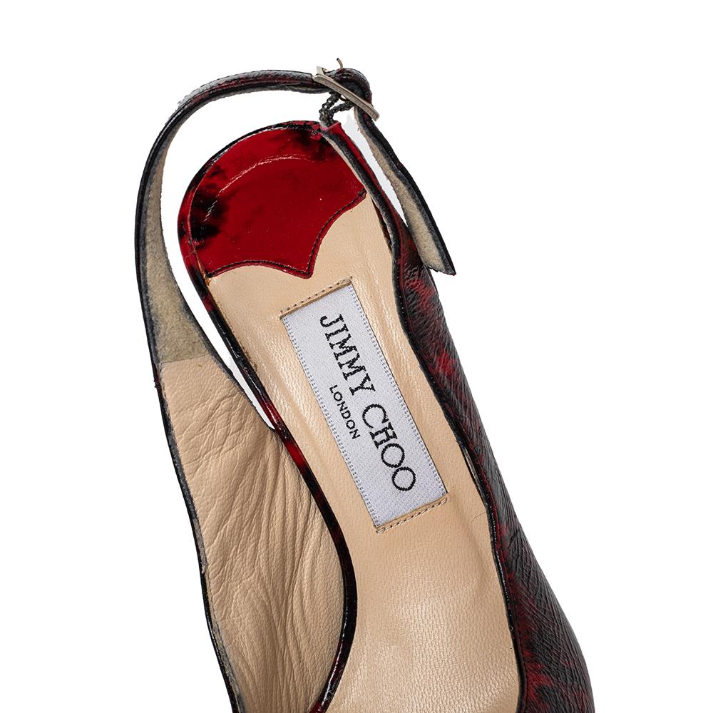 Be a trendsetter by waltzing out in this exquisite Jimmy Choo pair. Crafted from patent leather, these red & black beauties feature peep toes, stiletto heels, and buckle-held slingbacks. Slip them on over simple outfits and let these sandals have