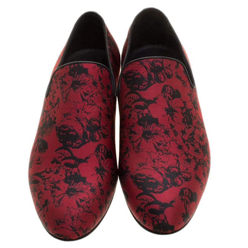 Red, hot and happening, these Jimmy Choo Sloane Smoking slippers are sure to win many hearts. It features a red floral jacquard fabric body. It comes with side cut-outs and finished with leather trims. Wear with those casual blazer looks to make a