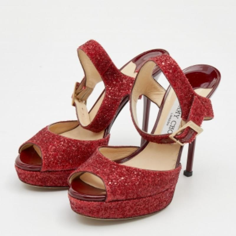 Feel luxuriously fashionable in these Jimmy Choo platform sandals. They have been crafted from ravishing red glitter and are finished with gold-tone buckles, slender 12.5 cm heels, and leather-lined insoles. Add them to your closet today!