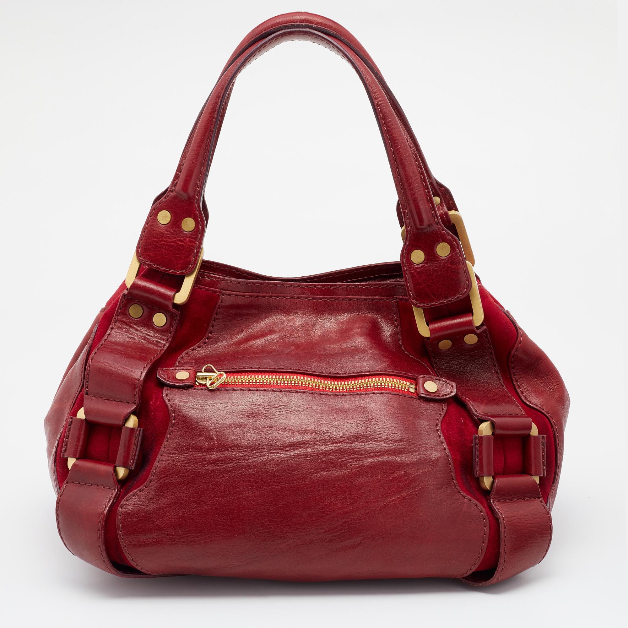 Step out in style by flaunting this stunning bag from Jimmy Choo. It has been crafted from leather and suede and shows the brand logo on the front. The red bag features dual handles, gold-tone zippers, and a spacious interior for all your essential