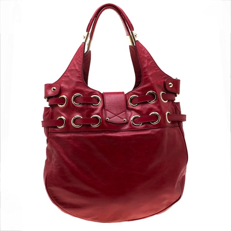 Own this gorgeous Jimmy Choo Riki tote today and light up your closet! Crafted from red leather, this stunning number has a flap top with a flip lock and a spacious suede interior. It features dual handles, gold-tone hardware and belt detailing.