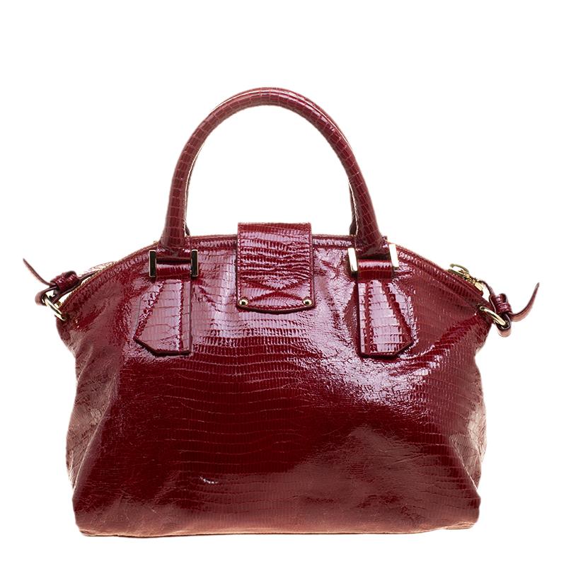 This Romeo satchel from Jimmy Choo will undoubtedly be your best buy. Flaunting a sturdy structure and red hue, the bag is crafted from lizard embossed patent leather. It is accented with dual top handles, a shoulder strap, and protective metal
