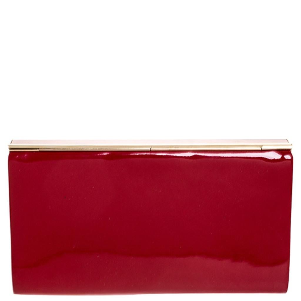 This Carmen clutch will woo you with its appealing curves and color. Crafted from patent leather, its smooth and glossy finish in red is beautifully complemented by a gold-tone metal frame. It has a satin-lined interior. Complete your evening look