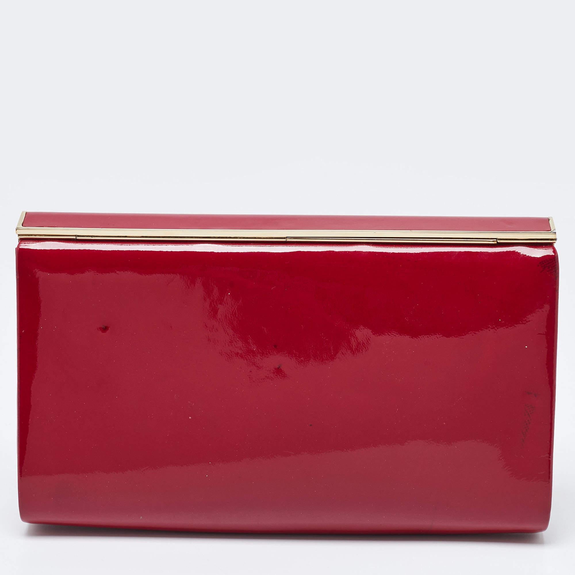 Complete an elite look with this Jimmy Choo frame clutch that is perfect for any party or formal event. It features a stunning red color on patent leather exterior with a gold-tone metal opening that leads to a well-sized satin interior. It makes