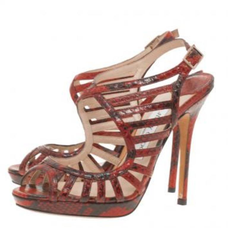 Marchez avec classe et style avec cette paire de sandales à plateforme en python Keenan de Jimmy Choo. Confectionné en python rouge, il est doté de brides à la cheville et de fermetures à boucle. Il est rehaussé de détails en métal doré. Elles sont