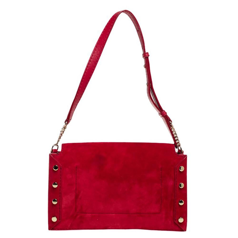 One of the signature detail of the Lockett by Jimmy Choo is the push-lock that has a pointed bottom. This shoulder bag boasts the same accent on its flap which secures a suede interior for your needs. The bag has a red suede exterior, gold-tone