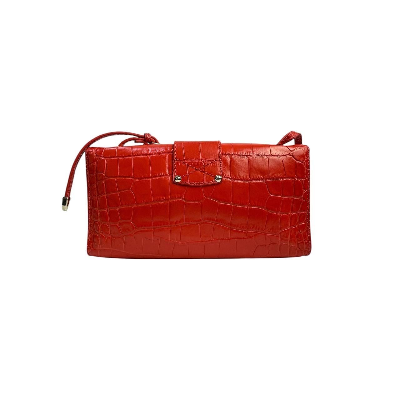 Élevez votre style avec ce superbe sac à bandoulière Jimmy Choo River ! Confectionné dans un luxueux cuir gaufré au crocodile orange et rehaussé d'élégantes ferrures dorées, ce sac est une véritable pièce d'apparat.

Parfait pour ajouter une touche