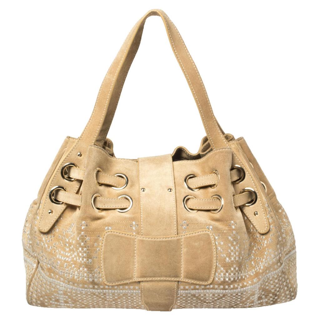 The popular Ramona is another perfectly designed, practical handbag from Jimmy Choo. Crafted from gold embroidered suede, it is accented with a flip-lock closure, and dual shoulder handles. The interior is lined with suede and features a zip