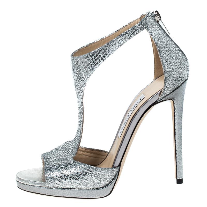 Jimmy Choo brings forth a classic pair of sandals that exudes a look of sophisticated grace when paired with any ensemble. These shimmery sandals are crafted from coarse glitter into a chic T-strap silhouette that makes them perfect accessories for