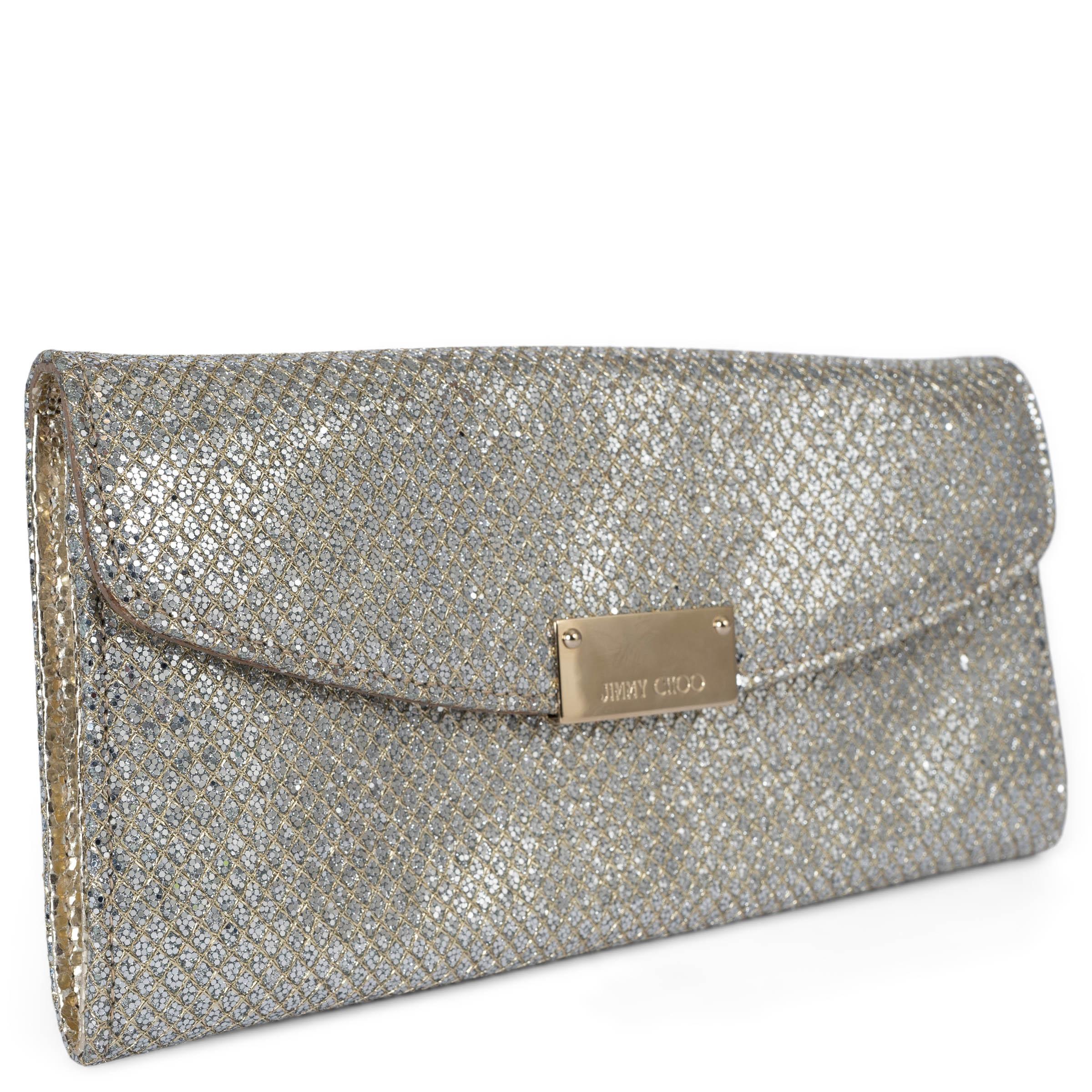 This 100% authentic Jimmy Choo Riane clutch is crafted from dazzling silver glitter fabric, perfect for adding a touch of glamour to any occasion. It features a detachable gold-tone chain strap and a logo-engraved plaque on the front. The clutch