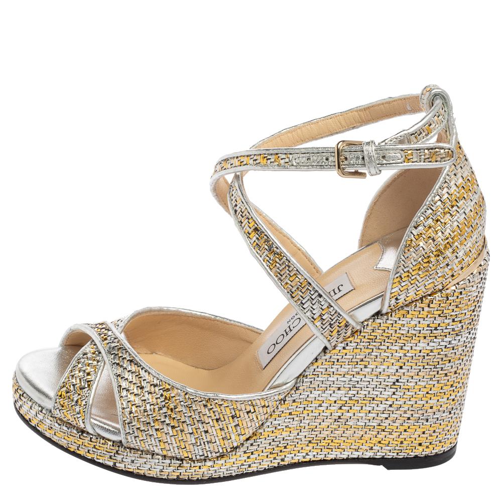 How beautiful are these Alanah sandals from Jimmy Choo! They are made from silver-gold woven leather and flaunt wedge heels, an ankle strap, and a crisscross strap on the front. They are adorned with gold-toned hardware. Match them with your outfit