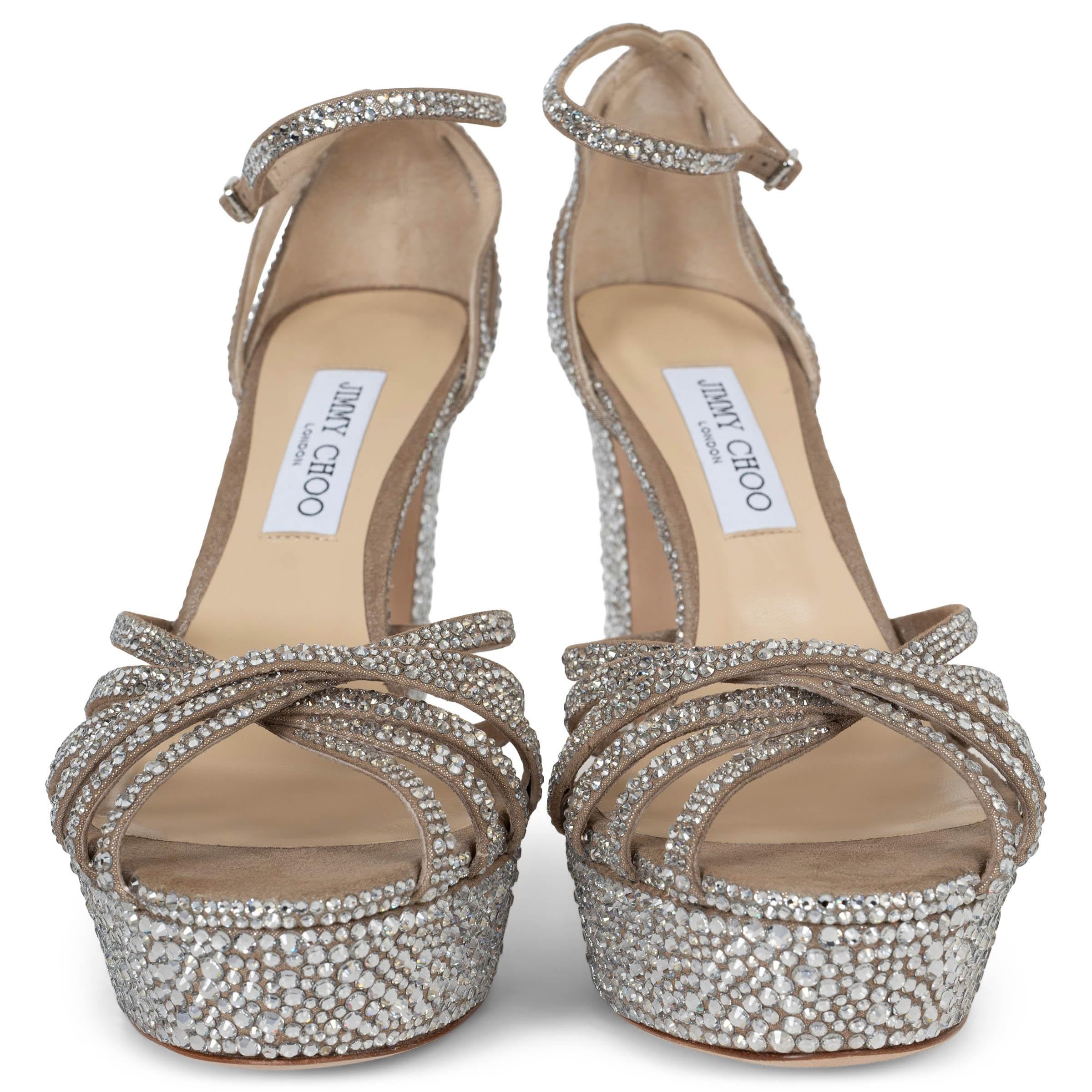 Estas sandalias de plataforma Isra 100% auténticas de Jimmy Choo destilan glamour clásico con su diseño atrevido y voluminoso. Fabricadas en ante con un acabado brillante, estas sandalias están adornadas con los característicos adornos de cristal,