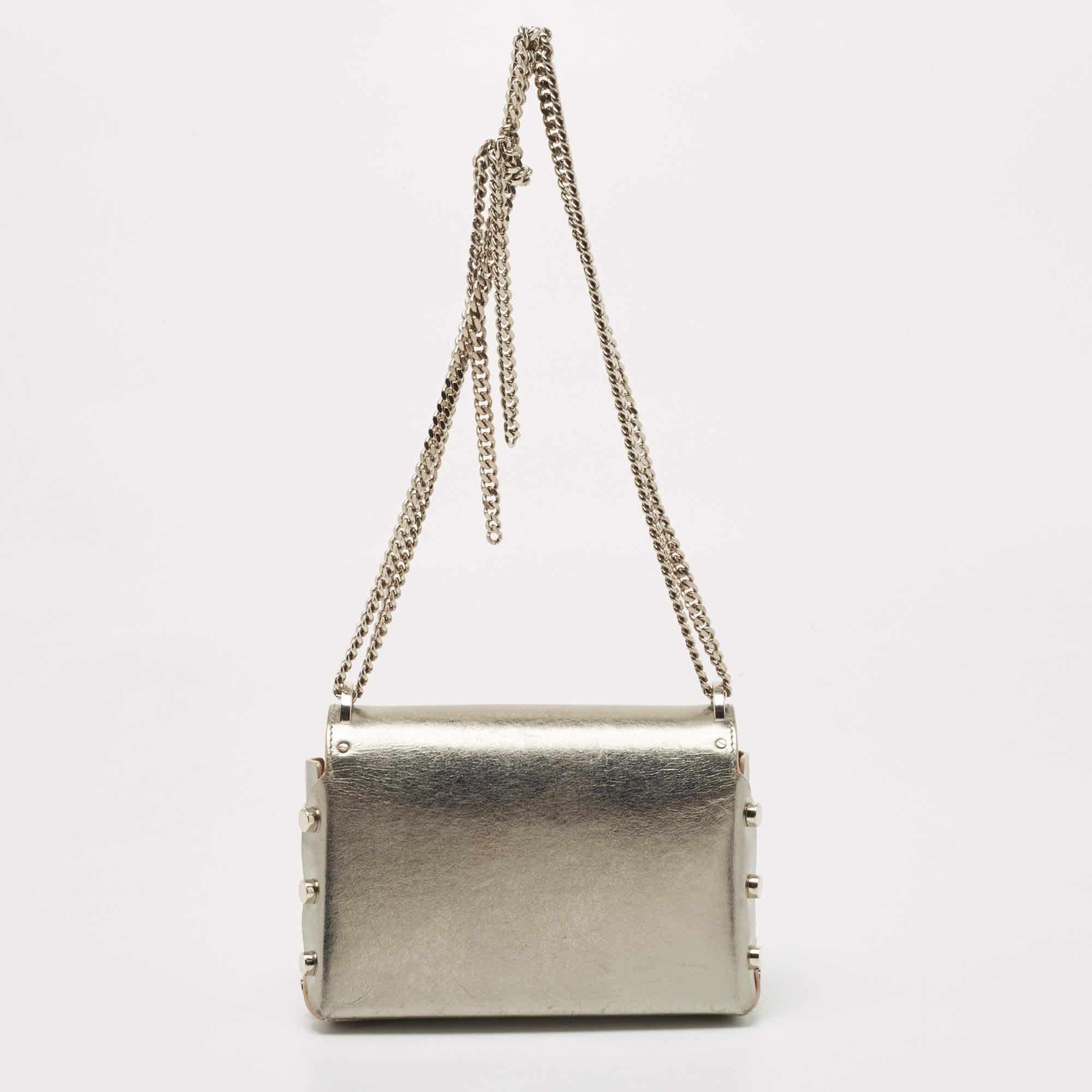 One of the signature details of this bag by Jimmy Choo is the push-lock that has a pointed bottom. This shoulder bag flaunts a super-stylish design and secures a suede interior. It has a gorgeous silver leather exterior and is a statement creation