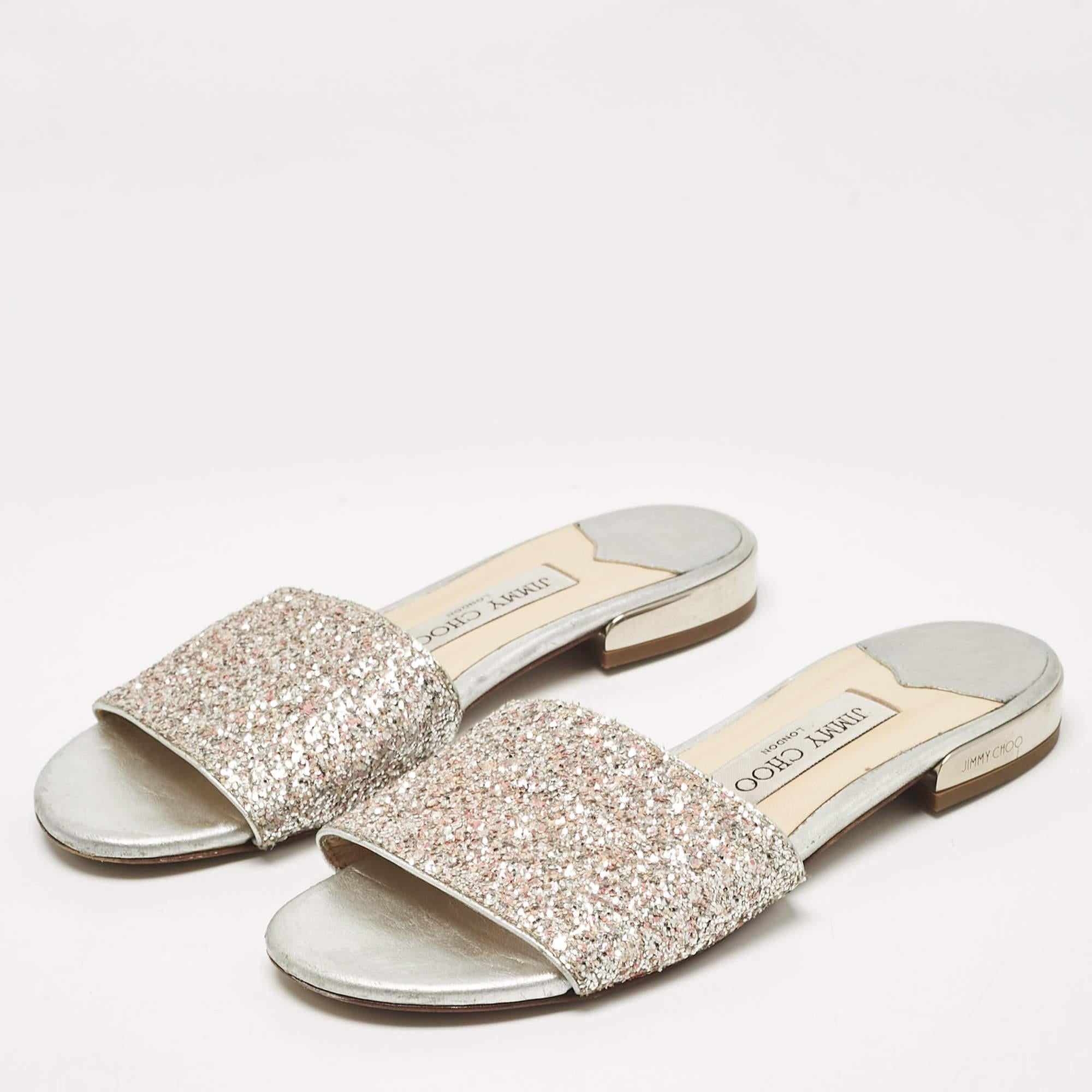 Style and comfort come together in these flat slides by Jimmy Choo. Made to delight they have been crafted in Italy from glitter fabric. The Joni slides have broad vamps leather lining insoles that feature the brand label and durable soles. They are