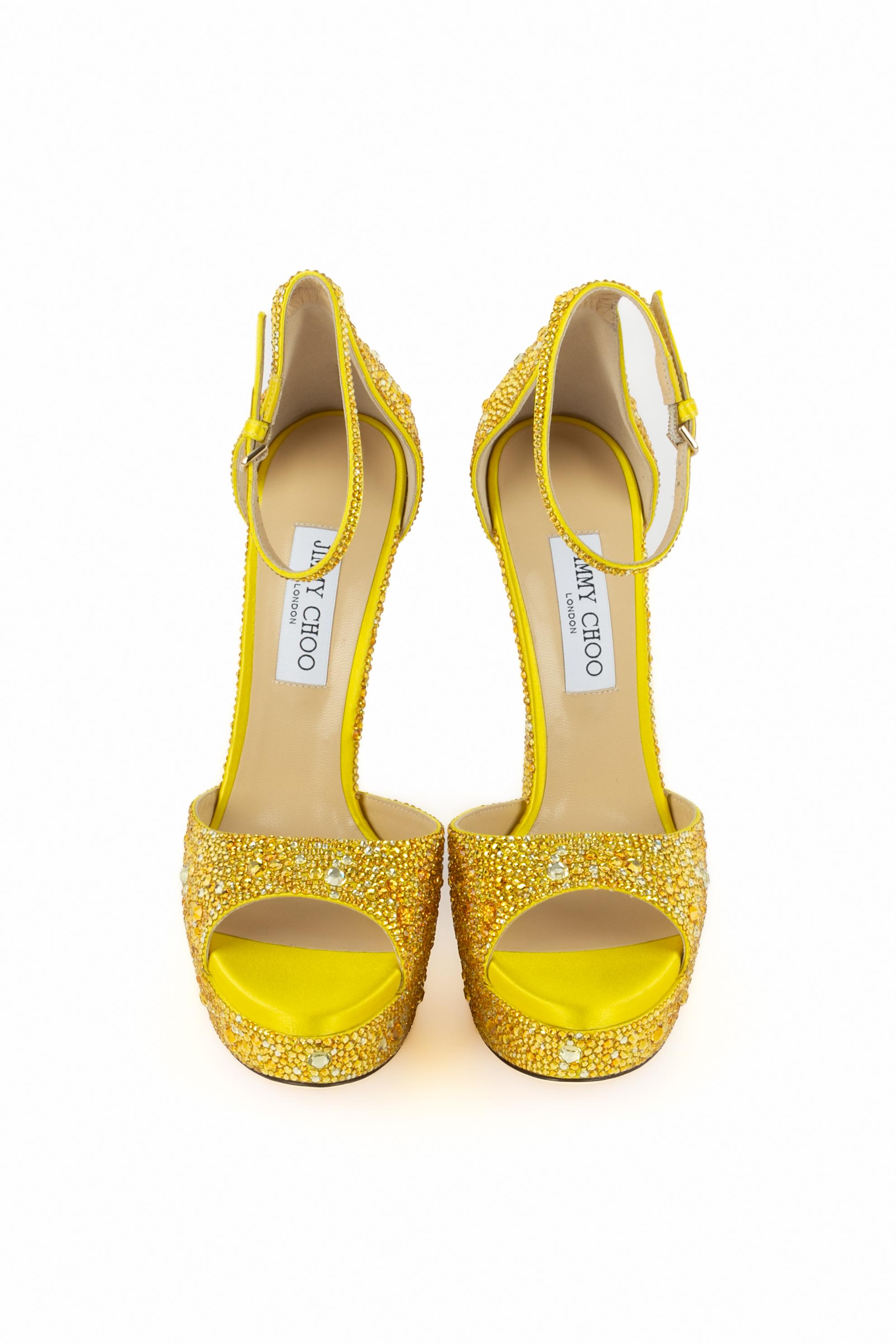 JIMMY CHOO - (Made in Italy) Gelbe, mit verschieden großen Strasssteinen verzierte Plateau-Stilettos aus Satin, offene Schuhspitzen, Handgelenkriemen, Innensohle aus Leder. Größe 40FR.

Bedingung:
Sehr guter Zustand

Abmessungen:
Absatzhöhe: 16