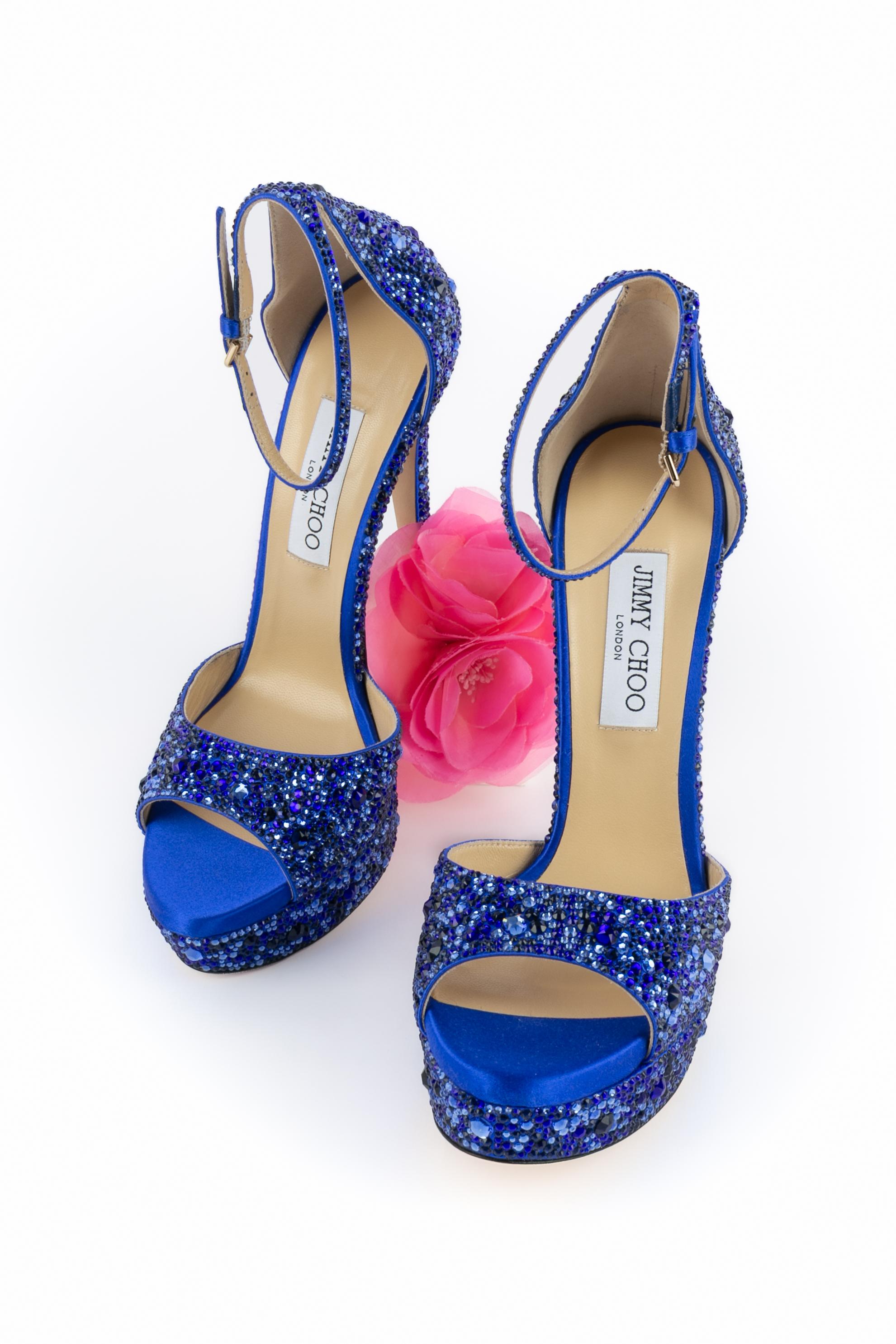 JIMMY CHOO - (Made in Italy) Tacchi a spillo con plateau in raso blu ornati da strass di diverse dimensioni, punte aperte e briglie da polso. Soletta in pelle. Taglia 40.

Condizioni:
Ottime condizioni

Dimensioni:
Altezza tacco: 17 cm - Plateau: 3