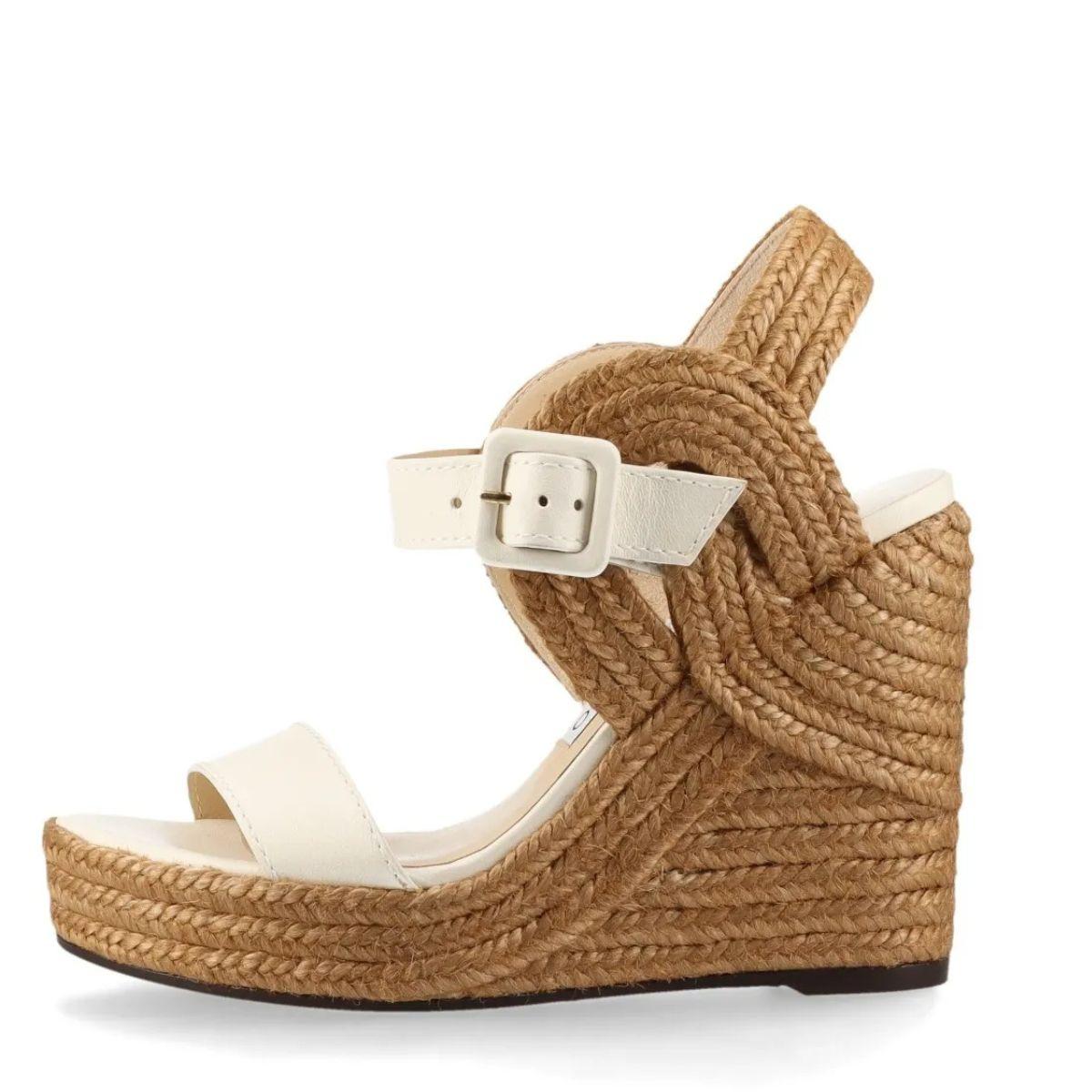 Il Jimmy Choo Strap Espadrilles Wedge Sandal in avorio emana un'eleganza senza sforzo con un fascino estivo e femminile. Realizzato con materiali morbidi e di alta qualità, il sandalo è caratterizzato da un classico design open-toe e da un cinturino