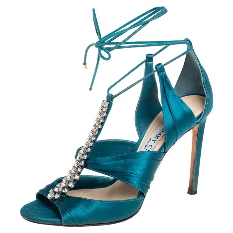 Never go out of style with this classy pair of sandals from the house of Jimmy Choo. Have everyone look at you in admiration with these teal blue satin sandals that are styled with open toes, crystal embellishments on the vamps, and self-tie ankle