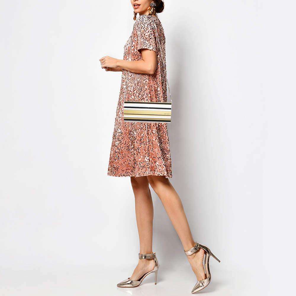 This clutch from Jimmy Choo has an appealing design  perfect to complement an evening dress or a party ensemble. Crafted from acrylic  leather and gold tone metal  the creation has a glossy appeal  a lined interior  and a chain handle.