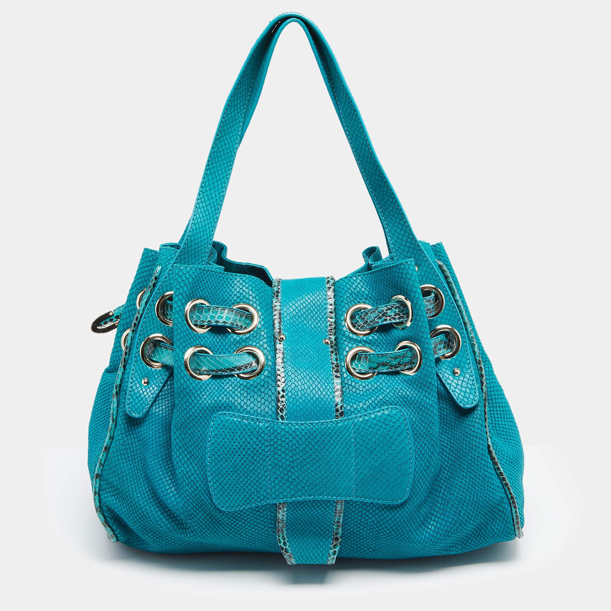 This Jimmy Choo Riki tote results from exquisite details and faultless craftsmanship. Created from turquoise embossed suede and snakeskin, this bag rules the wishlist of style enthusiasts worldwide. It is made striking with two straps passing