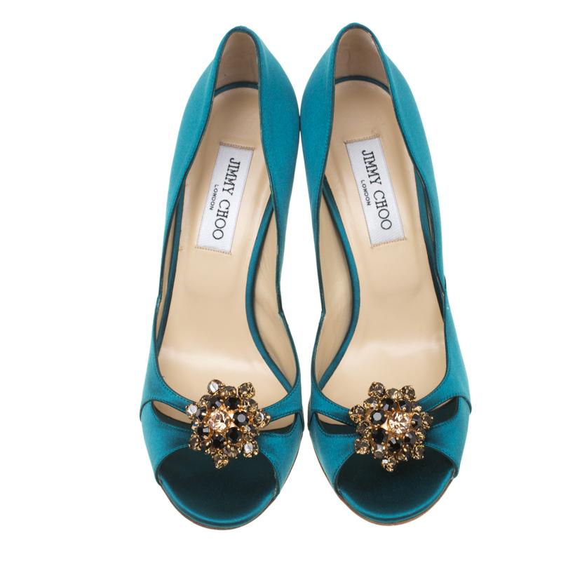 How gorgeous are these turquoise blue sandals from Jimmy Choo! They have been crafted from satin and styled with peep-toes. They flaunt a cut-out design on the vamps and an exquisite crystal embellishment detailing. They come equipped with