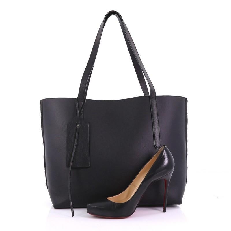 This Jimmy Choo Twist East West Tote Leather Medium, crafted in black leather, features dual leather straps, stud detailing and gunmetal-tone hardware. It opens to a beige suede interior with zip and slip pockets. **Note: Shoe photographed is used