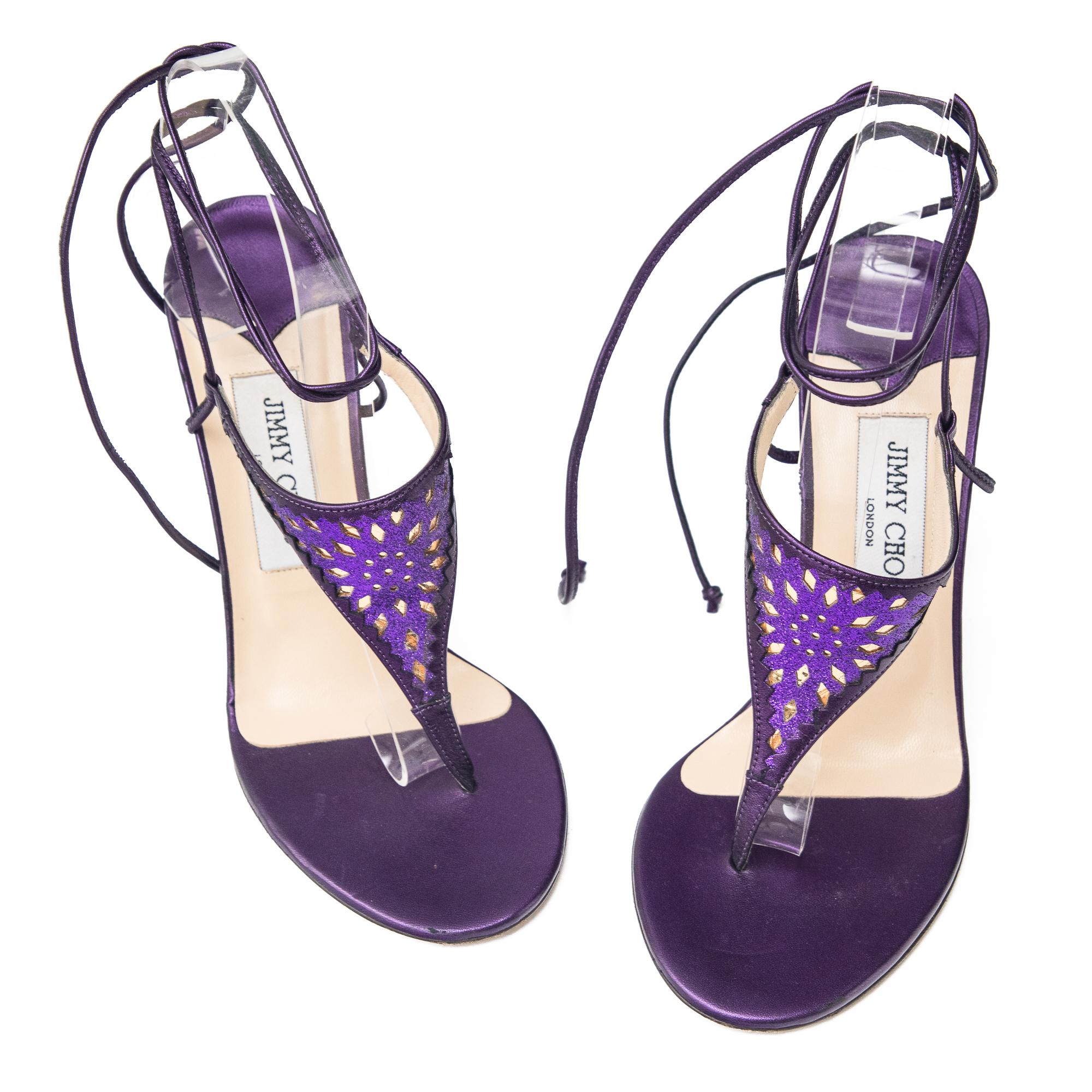 Ruder Than The Rest presents a pair of vintage Jimmy Choo lace up thong heels.

Geometric laser cut design possibly with Persian/Asian influences.

Purple leather construction.

Lace up ankle ties.

Stilleto heel.

Vintage, circa 2000s.

Made in