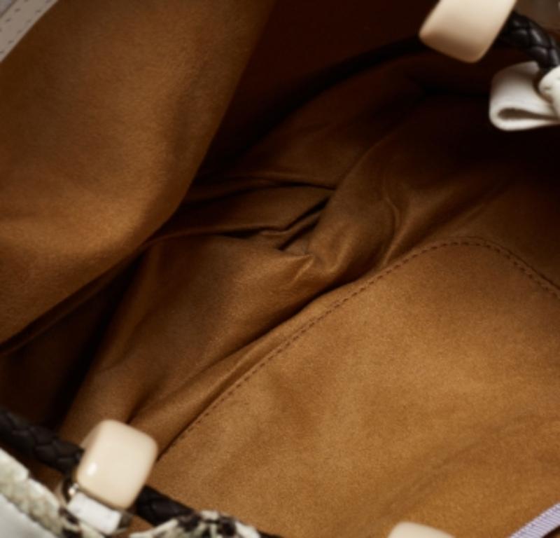Choose this Jimmy Choo hobo to complement your effortless everyday look. The bag is crafted from leather and features front embellishments, a flip lock closure, python trims, dual handles, and a tassel at the side. The suede-lined interior will