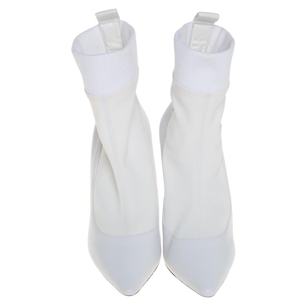 These gorgeous Jimmy Choo ankle boots will instantly elevate your style. This fabulous white pair is crafted in Italy and made of leather & fabric. The boots feature pointed toes, sleek heels, and logo detailing at the back. Team these trendy boots