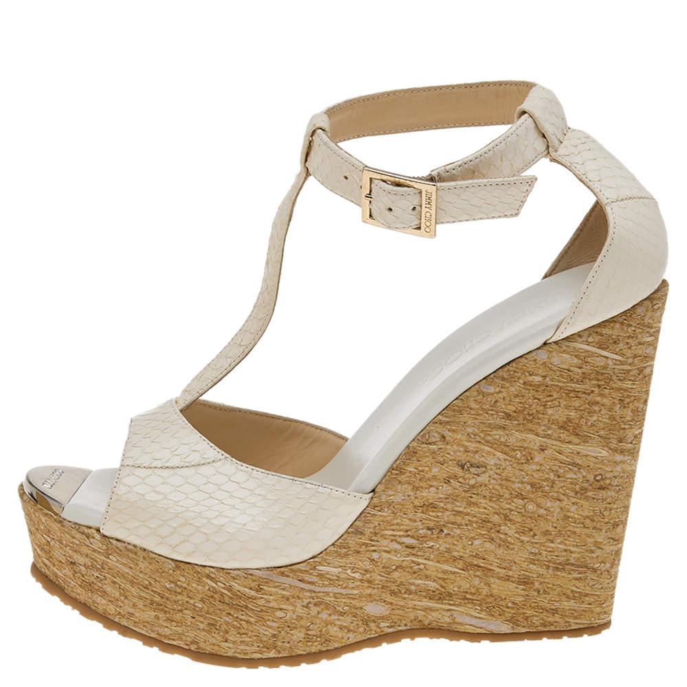 Your footwear collection can never be complete without comfortable and chic sandals like these. With these sandals from Jimmy Choo, comfort and style are guaranteed. They are made from white python leather and are installed with wedge platform heels